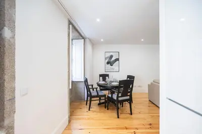a dining room and living room with a table and chairs at Elegant Downtown 1BR Flat w/ AC by LovelyStay in Porto