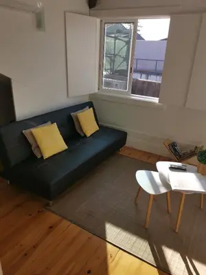 a living room with a black couch and a table at YOUR PLACE PORTO I in Porto