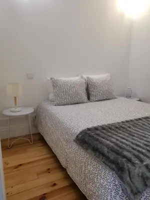 a bedroom with a bed and a table with a lamp at YOUR PLACE PORTO I in Porto