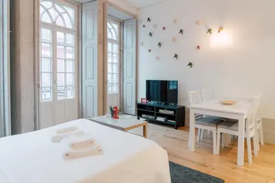 a room with a bed and a table and a tv at Casa Burguesa Rua do Almada - Porto city center in Porto