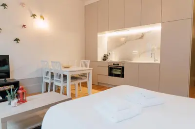 a white kitchen with a white table and chairs at Casa Burguesa Rua do Almada - Porto city center in Porto
