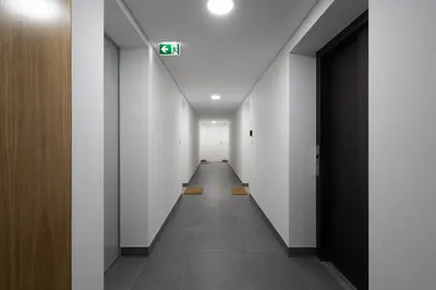 a long hallway with white walls and a sign on the ceiling at Habitatio - Bom Sucesso by LuxiStay in Porto