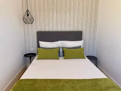 a bedroom with a bed with two green pillows at Santo António Charming Flat in Porto