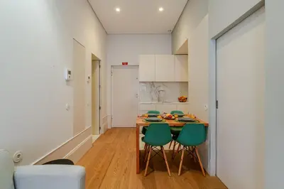 a kitchen with a table and four green chairs at Host Wise - Modern Stuning Flat w Prime Location in Porto