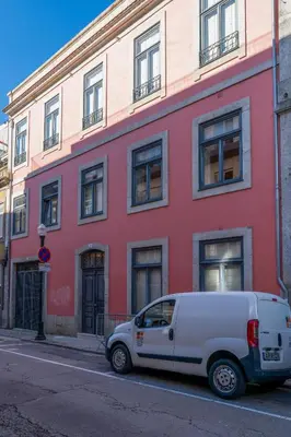 a white van parked in front of a red building at Host Wise - Modern Stuning Flat w Prime Location in Porto