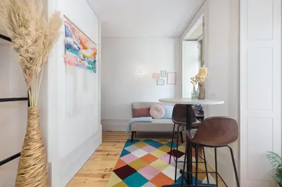 a living room with a table and chairs at Vibrant flat by São Bento w/balcony - Loureiro140 in Porto