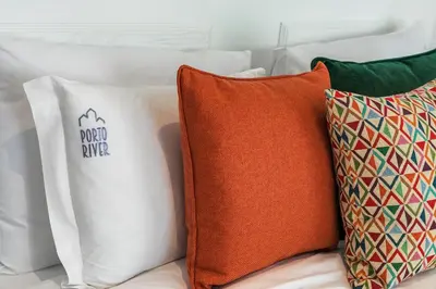a group of pillows sitting on top of a bed at Porto River Infante in Porto