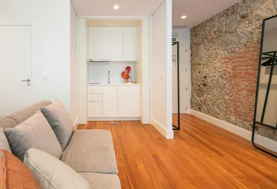 a living room with a couch and a brick wall at Porto River Infante in Porto