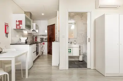 a kitchen with white appliances and a white table at Center Liberty Apartment in Porto