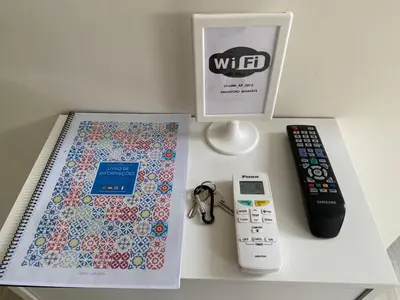a table with a remote control and a book and a remote controller at Center Liberty Apartment in Porto