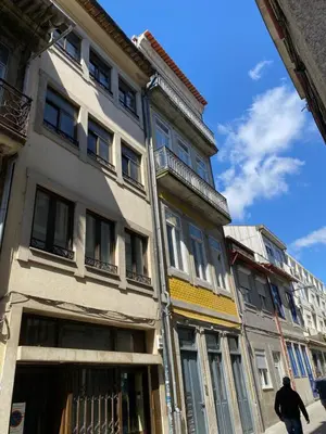 a man walking in front of a building at Center Liberty Apartment in Porto