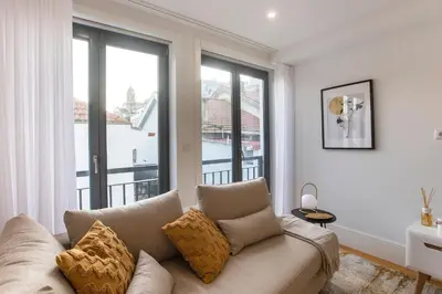 a living room with a couch and a large window at City Center 2BR Flat w/ AC by LovelyStay in Porto