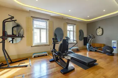 a gym with several treadmills and ellipticals in a room at Oca Vitoria Village in Porto