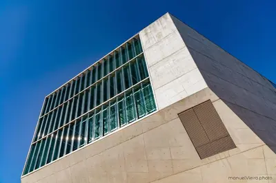 a tall building with green windows on a blue sky at Rolé Douro - Almada 340 in Porto