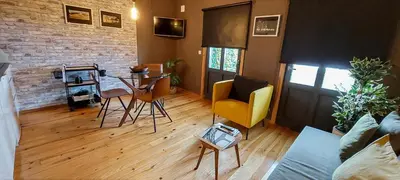 a living room with a table and chairs and a brick wall at Rolé Douro - Almada 340 in Porto