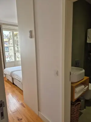 a bedroom with a bed with white sheets and purple pillows at PORTO DOWNTOWN Rua das FLORES in Porto