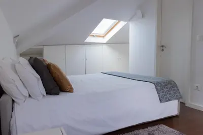 a bedroom with a white bed with a skylight at North Star Flats @Santa Marinha in Vila Nova de Gaia