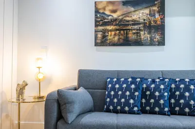 a blue couch in a living room with a painting at Sunshine Apartment in Porto