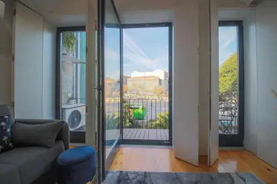 a living room with a couch and a large window at Sunshine Apartment in Porto