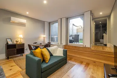 a living room with a green couch and a window at Camellia Garden in Porto