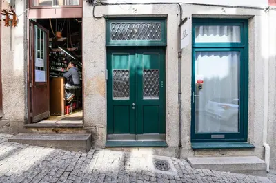 a green door on the side of a building at Maria da Sé Historic House in Porto