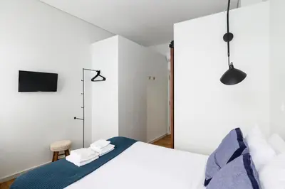 a bedroom with a bed and a tv on the wall at Maria da Sé Historic House in Porto