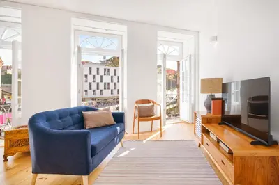 a living room with a blue couch and a tv at InBloom Apartments in Porto