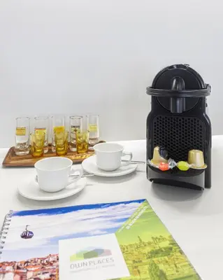 a table with two cups and a coffee maker at InBloom Apartments in Porto
