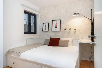 a bedroom with a white bed with a window at WHome Riverside View Premium Apartment w/ AC & Terrace in Porto