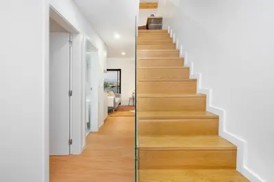 a stairway in a home with white walls and wood floors at WHome Riverside View Premium Apartment w/ AC & Terrace in Porto