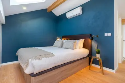 a bedroom with a blue wall and a bed at WHome Riverside View Premium Apartment w/ AC & Terrace in Porto