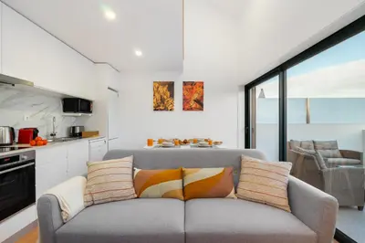 a living room with a couch and a kitchen at WHome Riverside View Premium Apartment w/ AC & Terrace in Porto