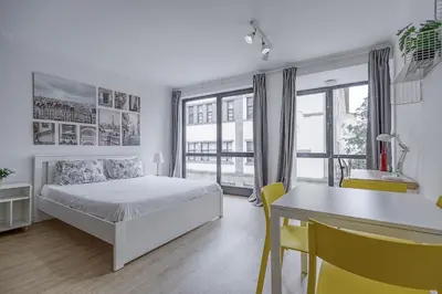 a white bedroom with a bed and a table and chairs at Travel & Live Alegria Apartments in Porto