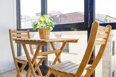 a table and two chairs and a plant on a window at Travel & Live Alegria Apartments in Porto