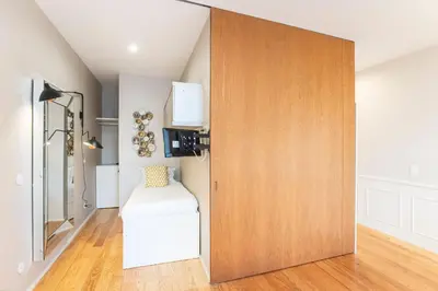a large wooden door in a room with a stool at Cute & Bright Flat w/ AC by LovelyStay in Porto