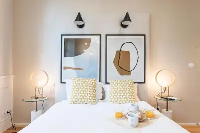 a bedroom with a white bed with two lamps at Cute & Bright Flat w/ AC by LovelyStay in Porto