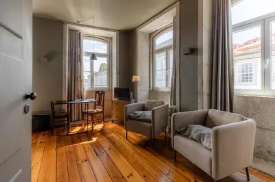 a living room with two chairs and a table at CLUBE Charming Apartments - Cedofeita in Porto