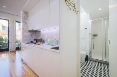 a white kitchen with a sink and a shower at THE TWIN Apartments in Porto