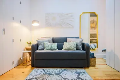 a blue couch in a living room with a mirror at THE TWIN Apartments in Porto