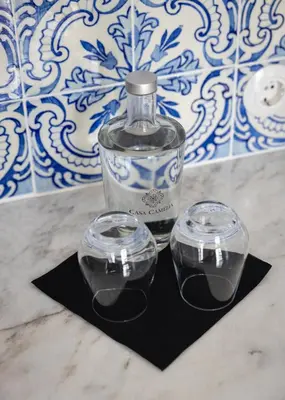 a bottle and two glasses sitting on a black napkin at CASA CAMÉLIA in Porto