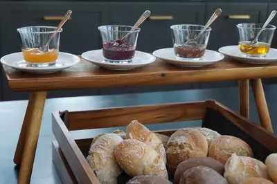 a wooden table with plates of pastries and cups of honey at CASA CAMÉLIA in Porto
