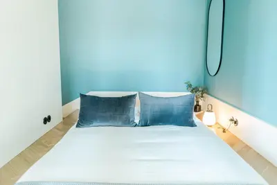 a bedroom with a bed with blue walls at Award Winning Design Apt City Center - River View by lisbeyond in Porto