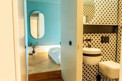 a bathroom with a toilet and a mirror at Award Winning Design Apt City Center - River View by lisbeyond in Porto
