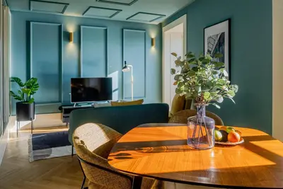 a dining room with a table with a vase of flowers at Award Winning Design Apt City Center - River View by lisbeyond in Porto