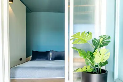 a bedroom with a bed and a potted plant at Award Winning Design Apt City Center - River View by lisbeyond in Porto