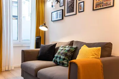 a living room with a brown couch with pillows at Elegant & Bright Flat by LovelyStay in Porto