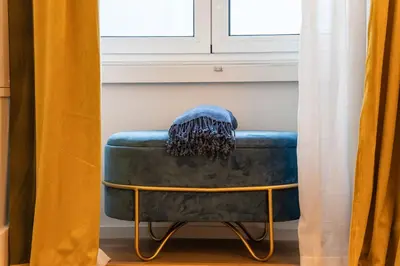 a blue couch sitting under a window with a blanket on it at Elegant & Bright Flat by LovelyStay in Porto