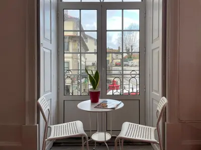 a table and chairs in front of a window at Oporto Blue Aliados - Historic City Center Studio in Porto