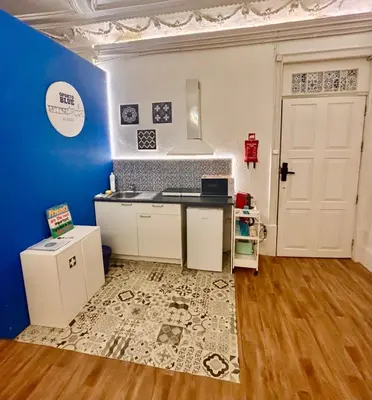 a kitchen with a counter and a blue wall at Oporto Blue Aliados - Historic City Center Studio in Porto