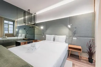 a bedroom with a large white bed and a bathroom at GuestReady - Mercadores 150 in Porto